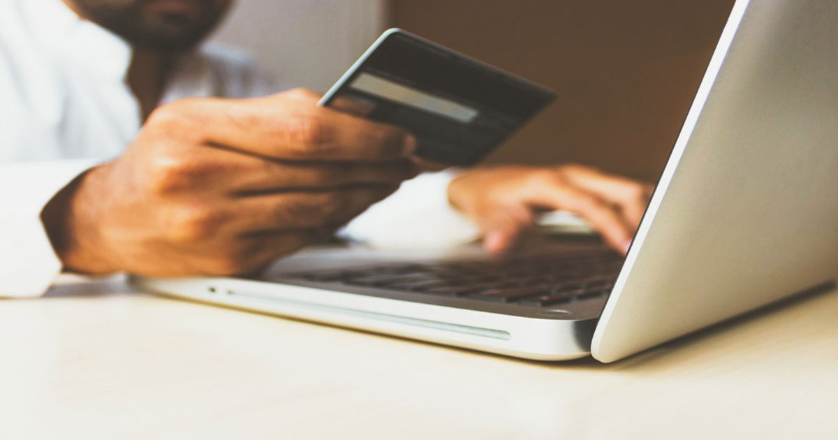 person with credit card on computer